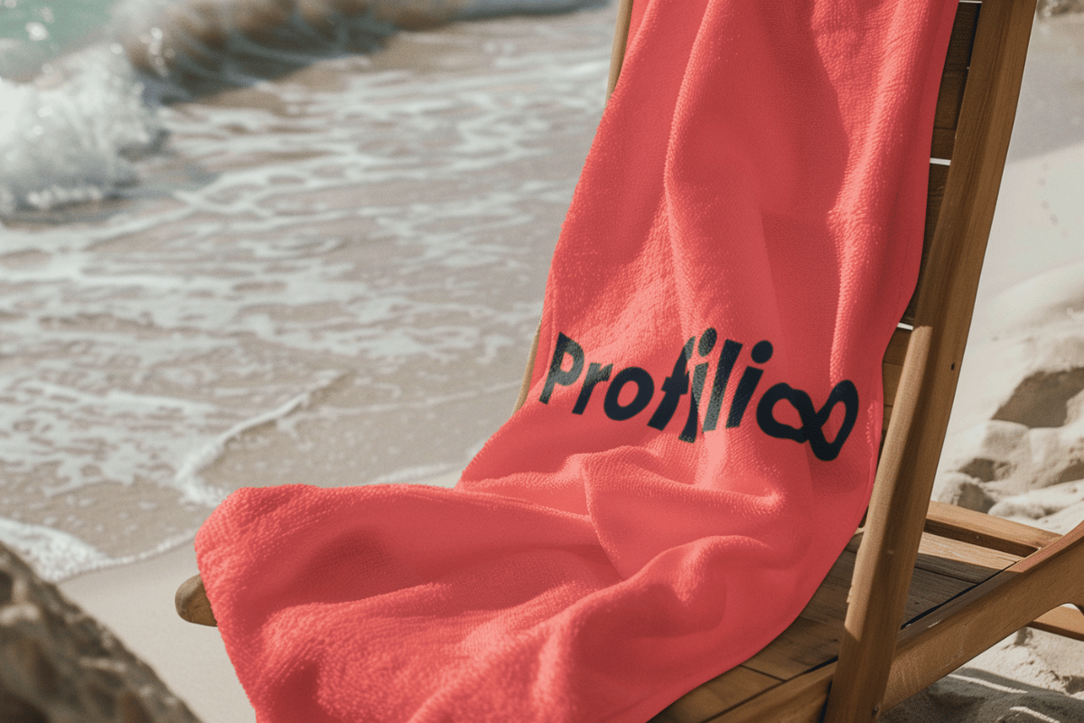 Et hådkle med trykt logo som henger over en strandstol